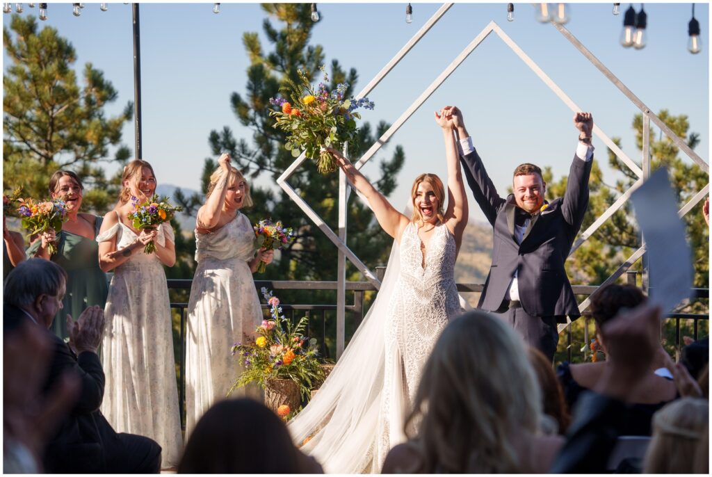 Bride and groom holding arms in the air at end of ceremony