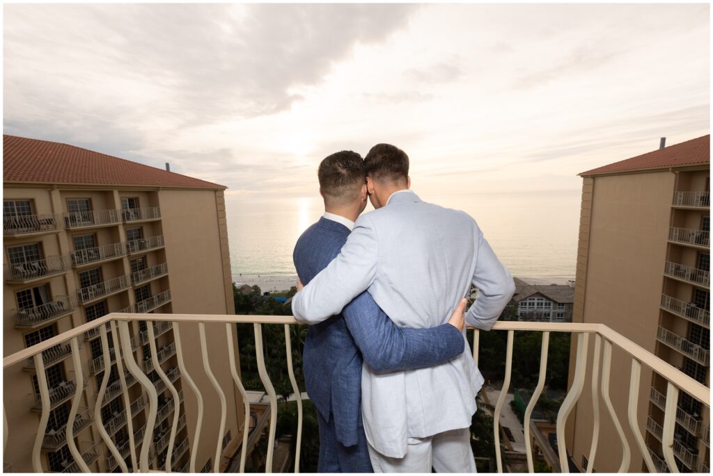 Grooms overlooking ocean from balcony at Ritz Carlton in Naples