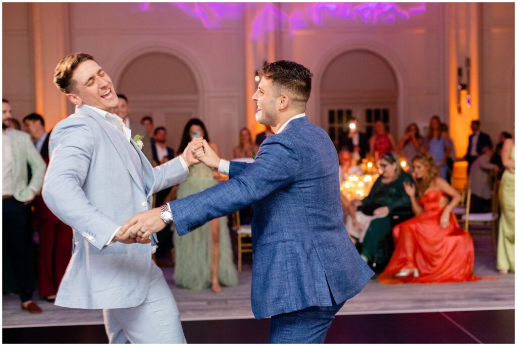 Grooms dancing and laughing together during wedding reception at Ritz Carlton in Naples