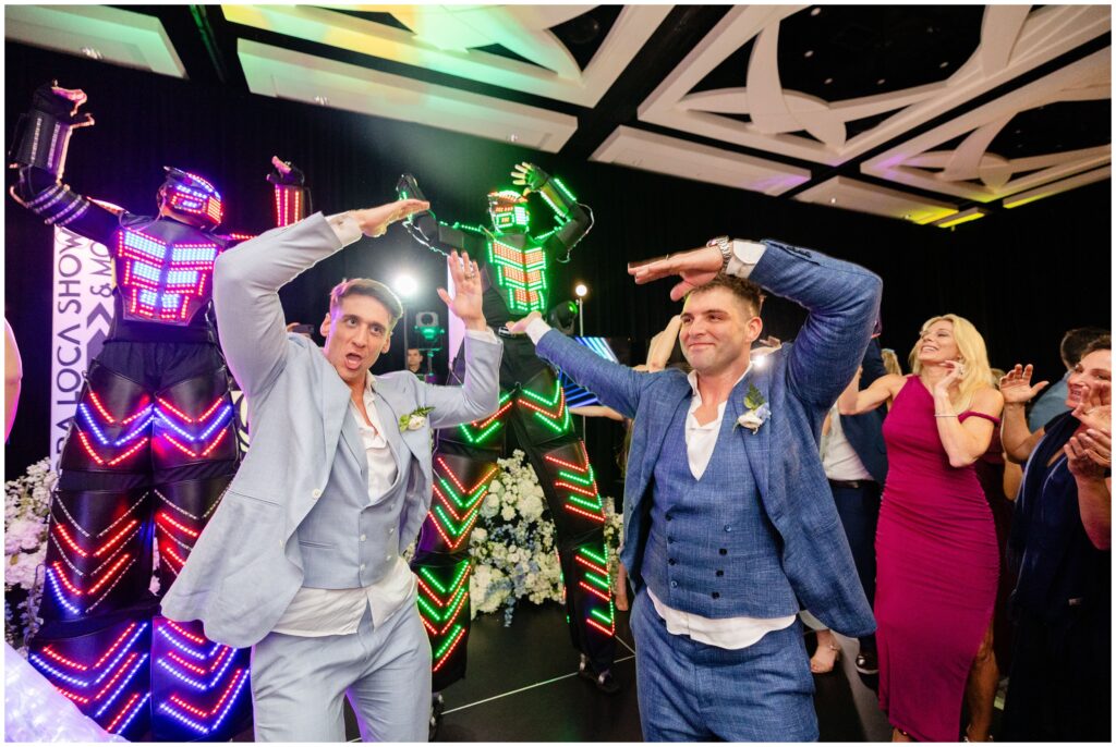 Grooms dancing with wedding guests on dance floor  during wedding reception at Ritz Carlton in Naples