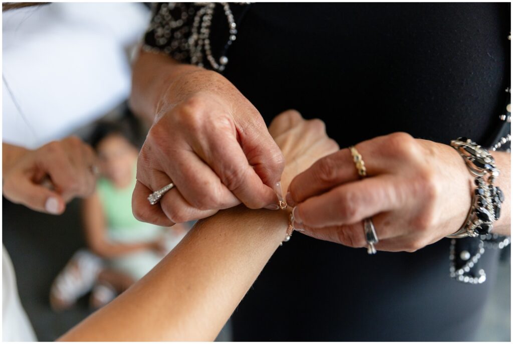 Bride getting bracelet put on while getting ready for wedding