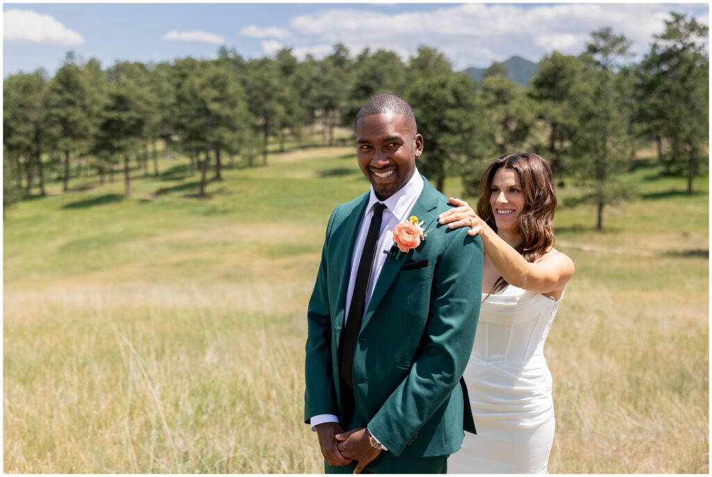 Bride tapping on shoulder of groom during first look at Boulder Creek by Wedgewood