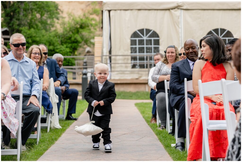 Ring bearer walking down isle for wedding at Boulder Creek by Wedgewood