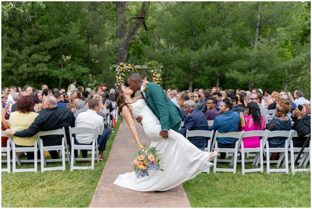 Bride and groom kiss at the end of isle after ceremony at Boulder Creek by Wedgewood