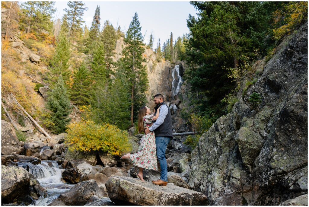 Couple standing on rocks during Engagement session in Fish Creek Falls Steamboat Springs