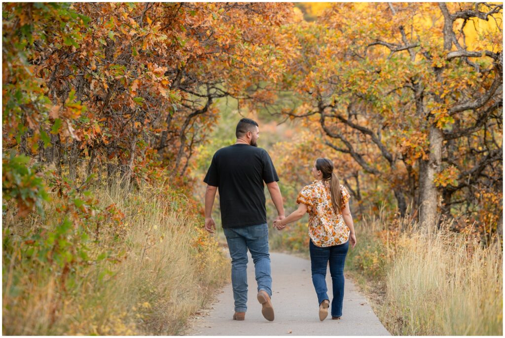 Couple walking down trail during Engagement session in Fish Creek Falls Steamboat Springs