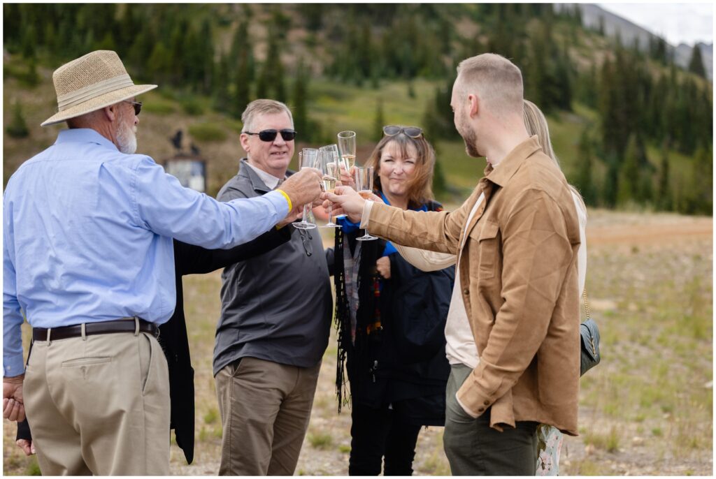 Couple celebrating with family after proposal in Breckenridge with chmapagne