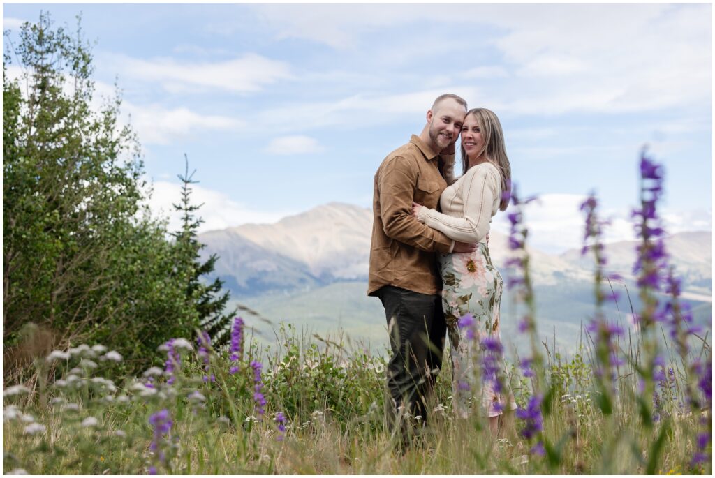 Couple standing in a flower filed in Breckenridge after proposal