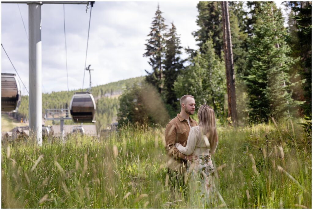 Couple hugging in grass field in Breckenridge after proposal