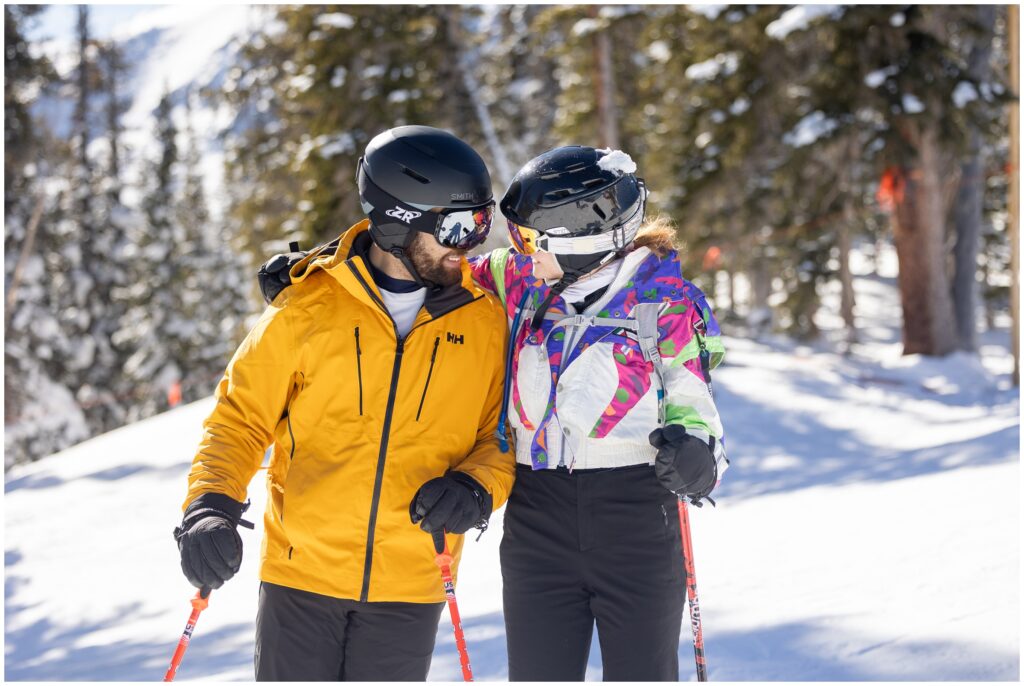 Couple looking at each other with ski poles after Breckenridge mountain proposal