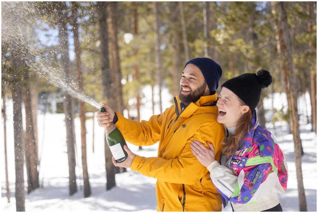 Couple celebrates with opening champagne after their Breckenridge mountain ski proposal