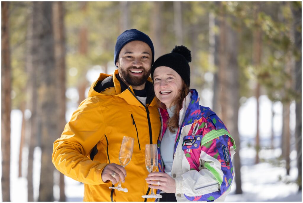 Couple drinking champagne after their Breckenridge mountain ski proposal