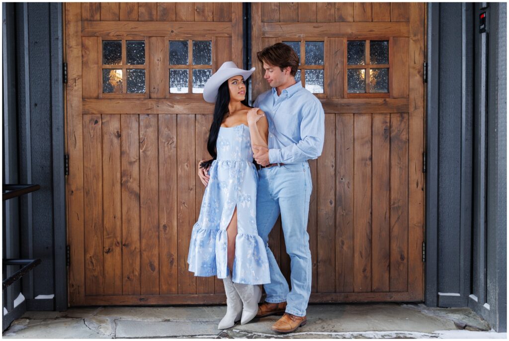 Couple outside of barn for engagement session at Devil's Thumb Ranch