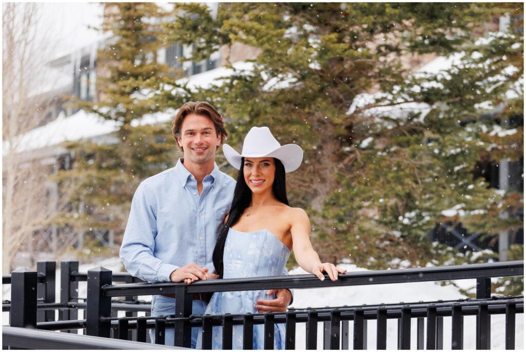 Couple on bridge for engagement session at Devil's Thumb Ranch