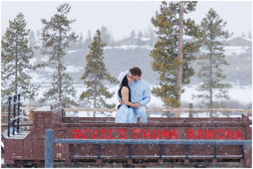 Couple standing on trailer for engagement session at Devil's Thumb Ranch