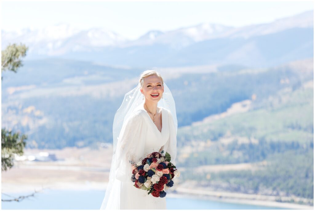 Bride holding boutquie overlooking lake