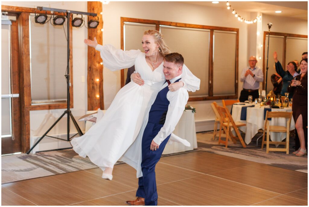 Groom lifting bride during first dance