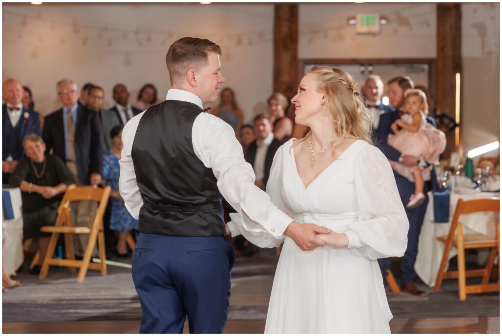 Bride and groom holding hands during first dance