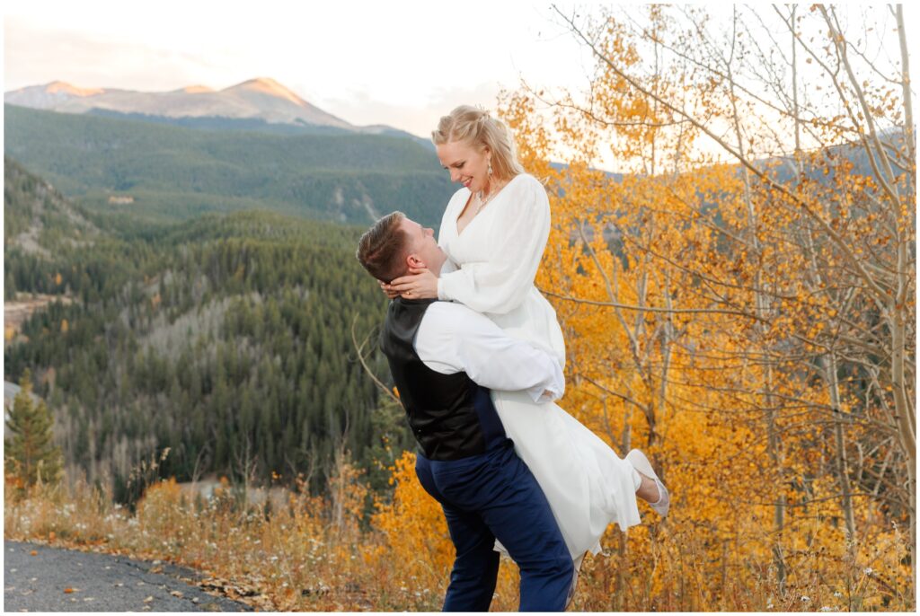 Groom lifting bride outside at The Lodge at Breckenridge