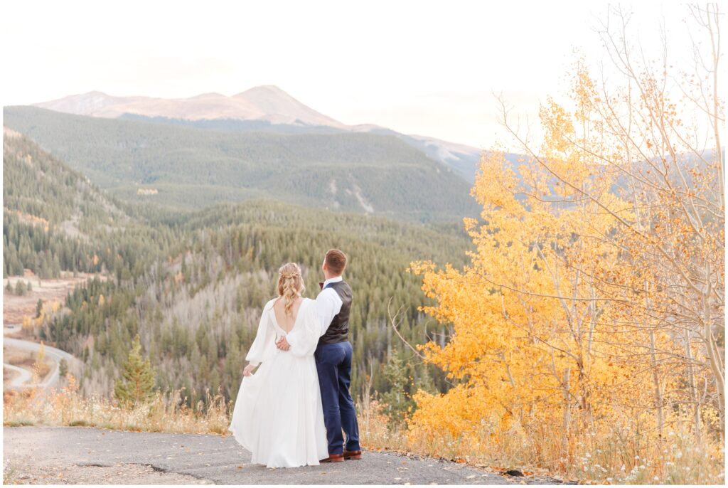 Bride and groom looking at mountains of Breckenridge with fall leaves