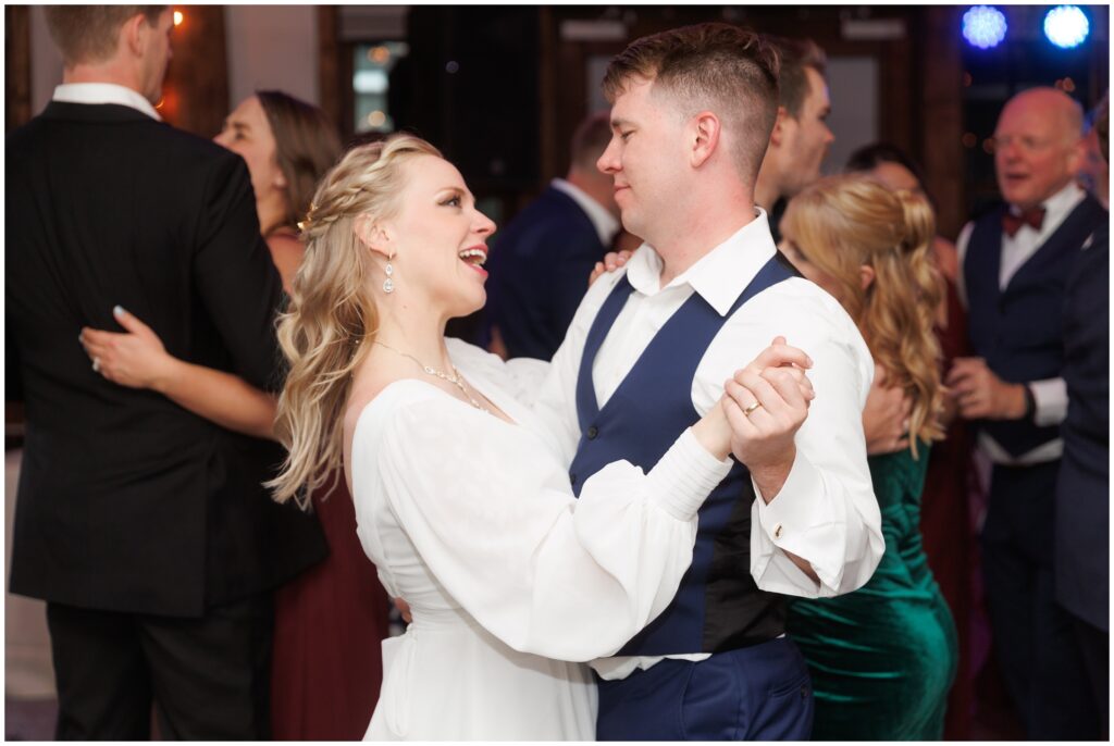 Bride and groom dancing with guests during open dancing