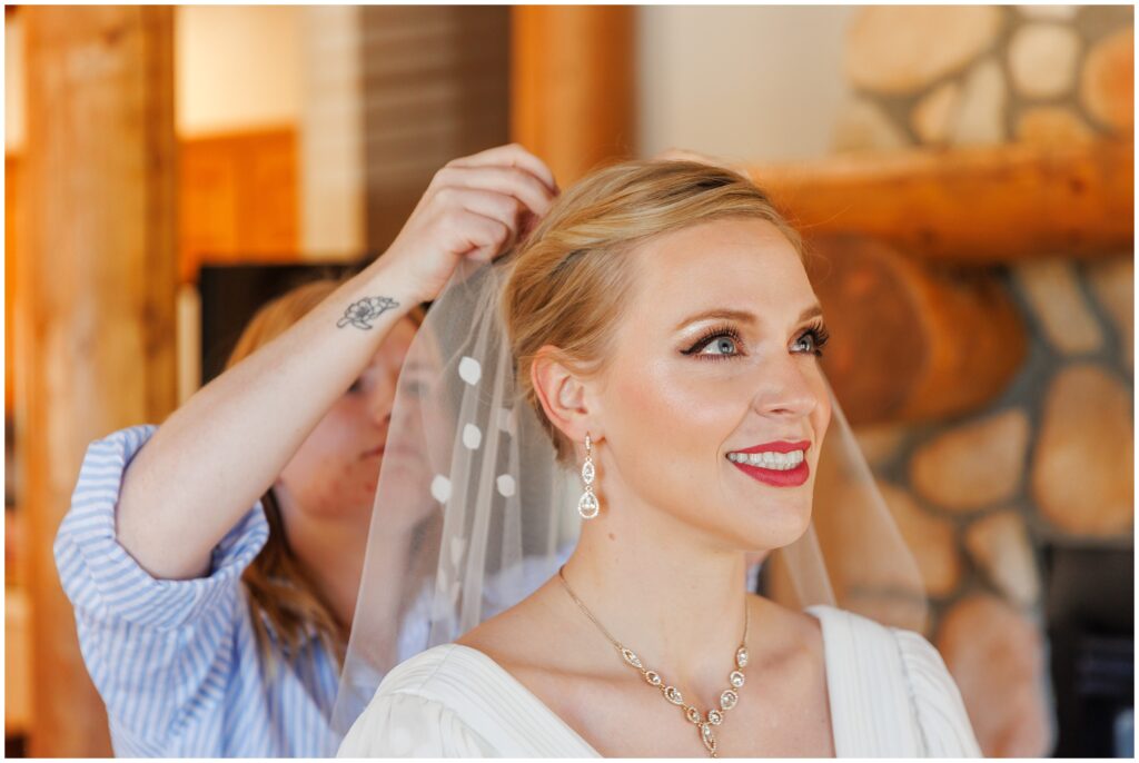 Bride getting help putting on veil for wedding