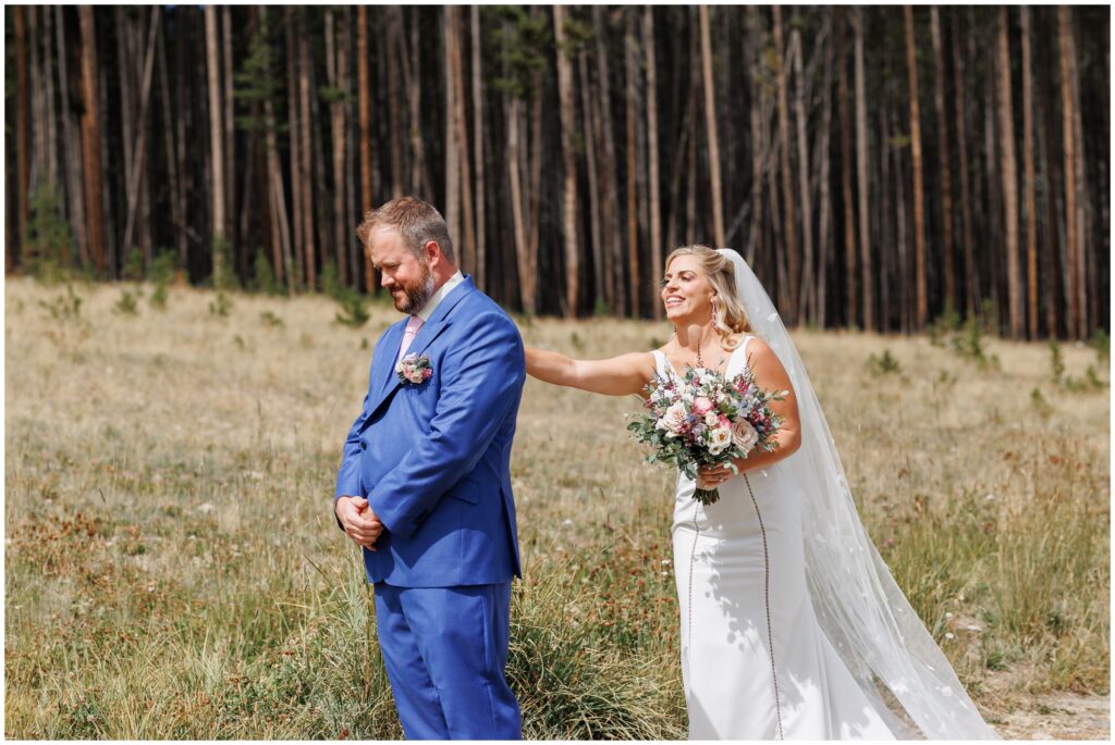 Bride tapping groom on shoulder for first look