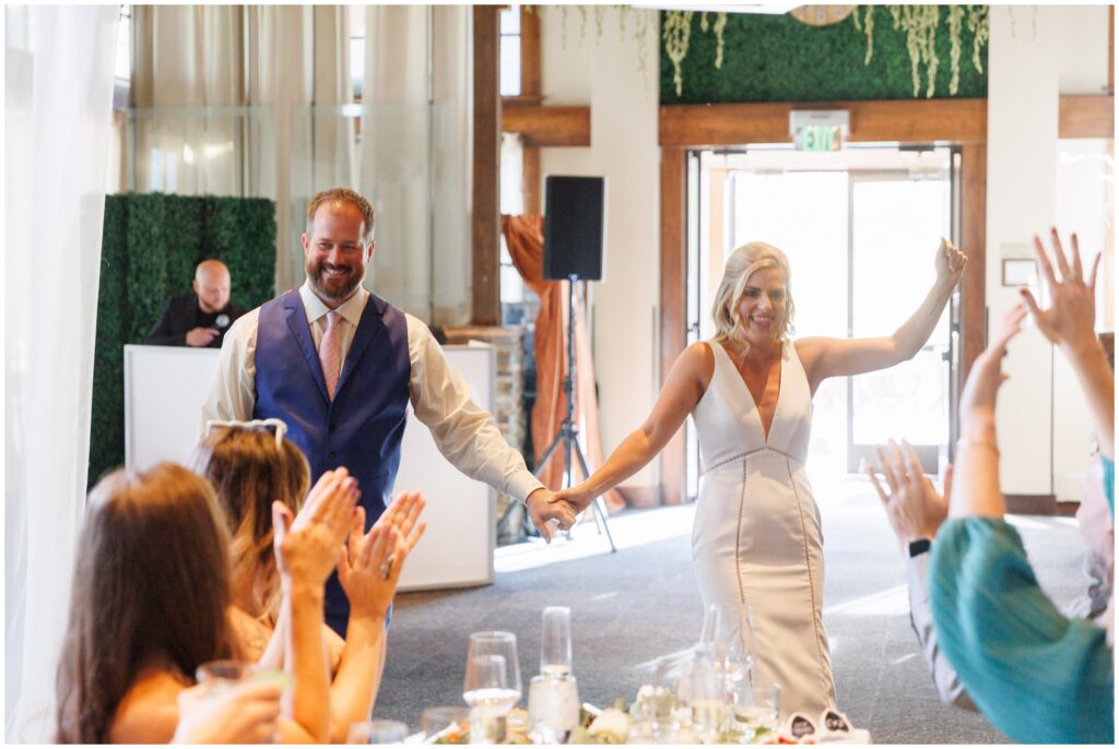 Guests cheering to bride and groom coming in for grand entrance at Sevens at Peak 7 in Breckenridge