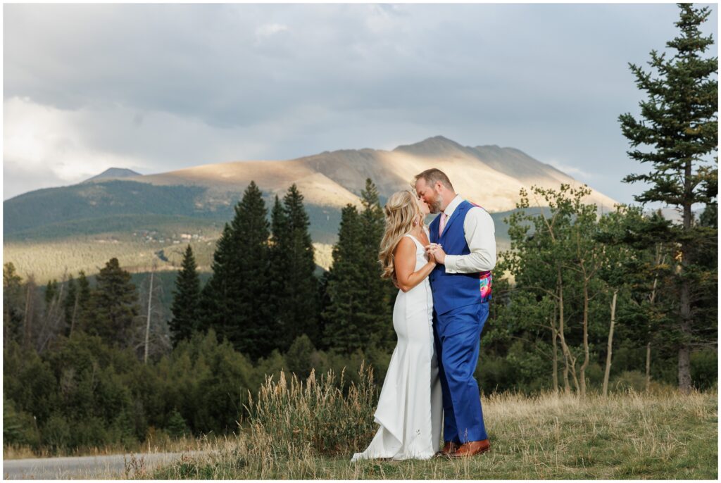 Bride and groom on grassy hill during sun down outside in Breckenridge