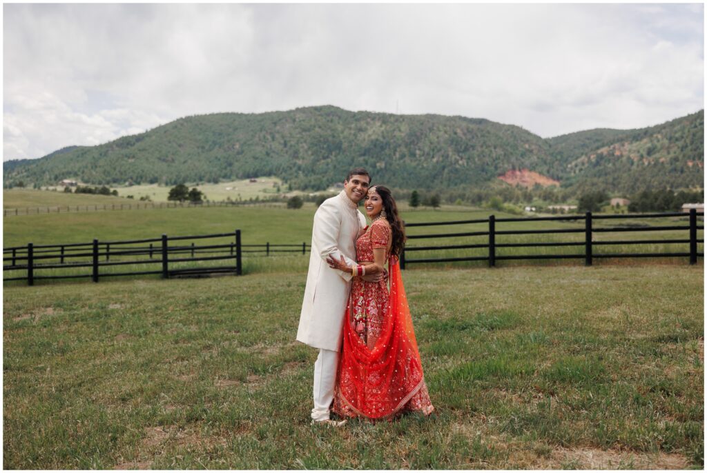 Bride and groom in grass filed at Spruce Mountain 