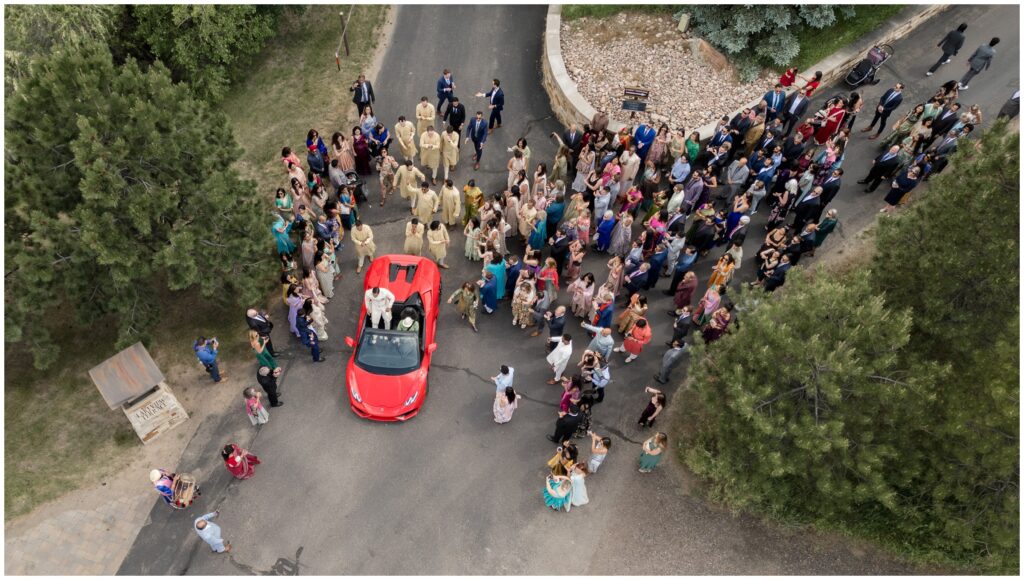 Guests around Lamborghini during baraat at Spruce Mountain 
