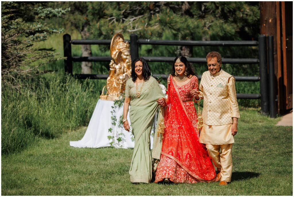 Bride walking down with parents at Spruce Mountain 