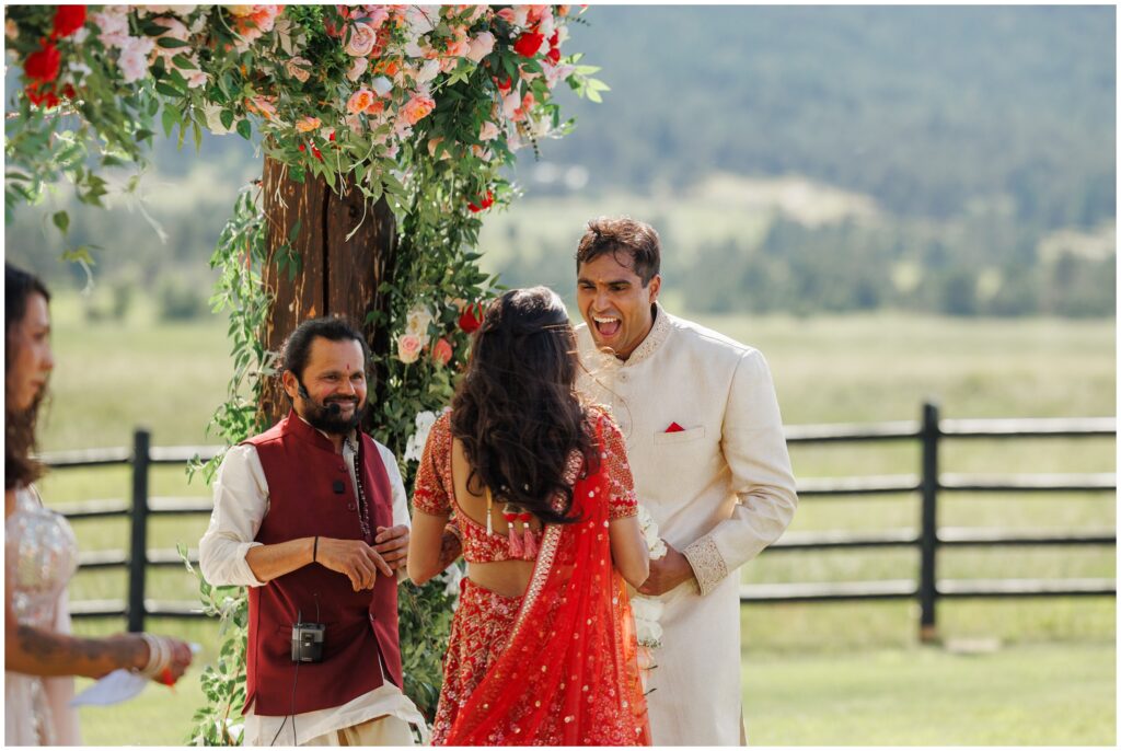 Groom smiling and holding hands with bride at Spruce Mountain 