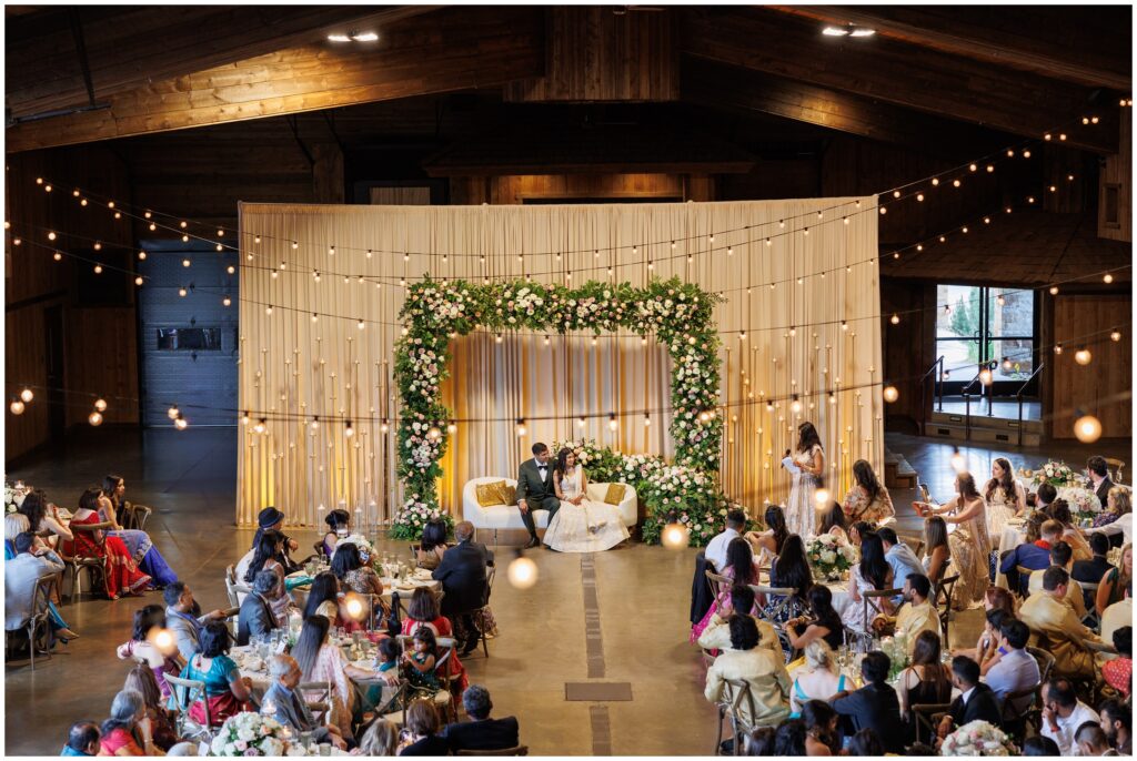 bride and groom seated with guests listening to toasts