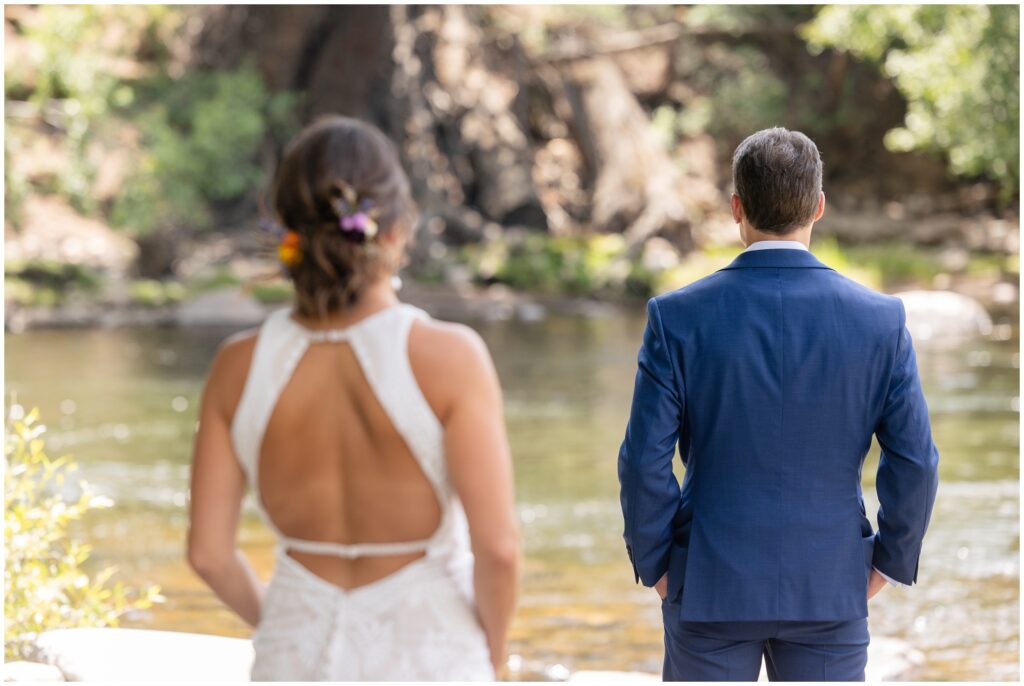 Bride walking behind groom for first look