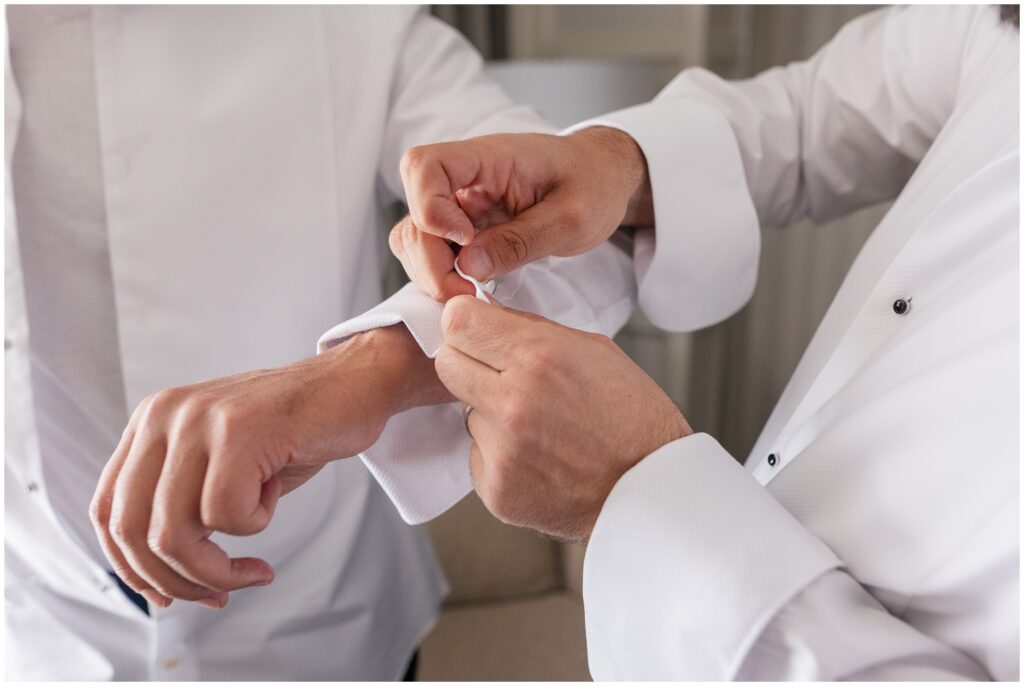 Groom putting on cufflinks