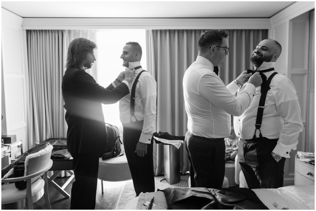 Groomsmen putting on bowties