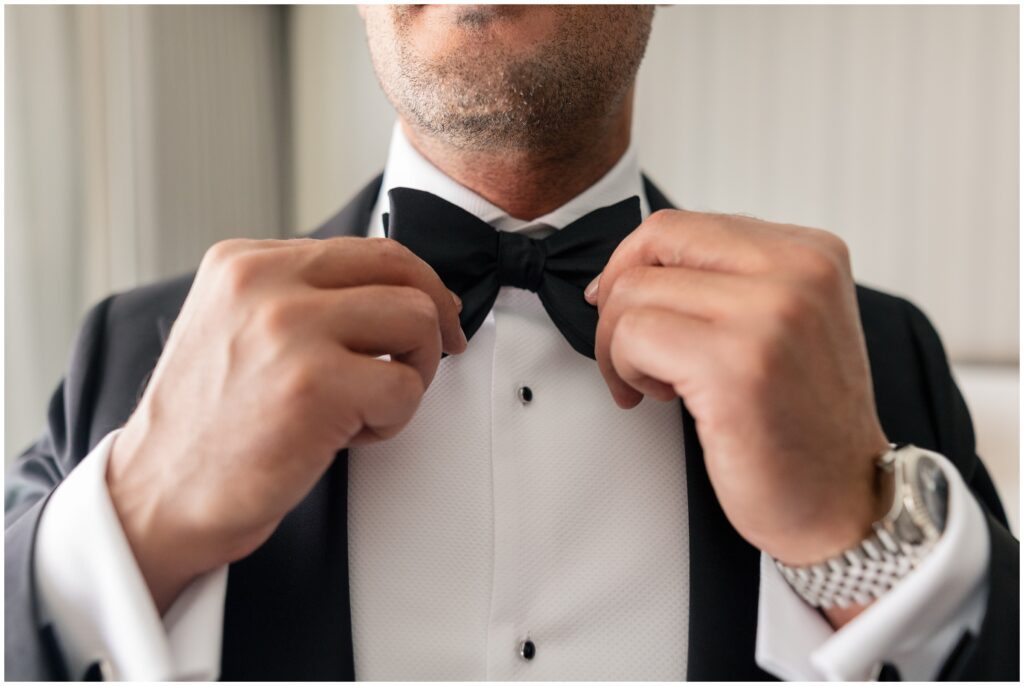 Groom adjusting bowtie