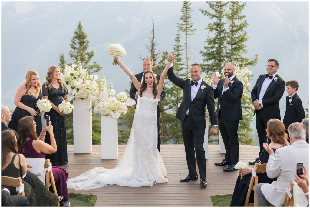 bride and groom hold and raise hands at end of ceremony
