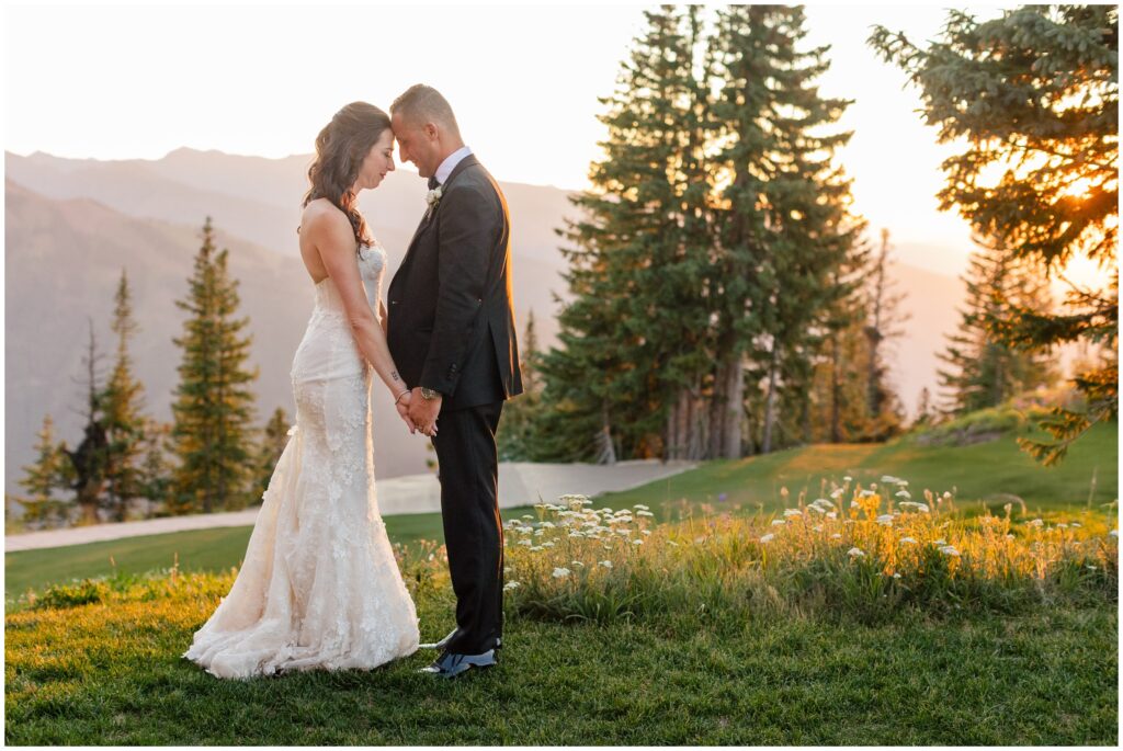 bride and groom foreheads touching with sunset
