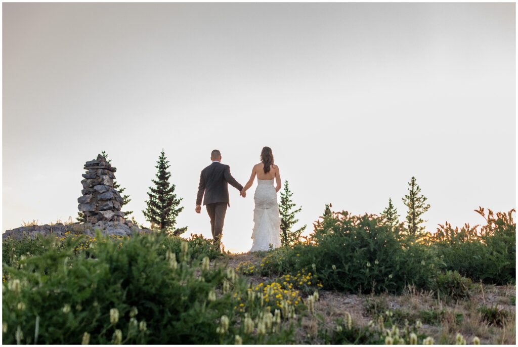 bride and groom walking up trail
