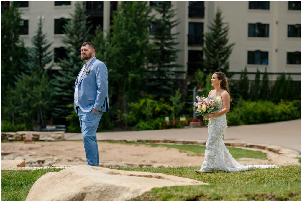 Bride walking behind groom for first look