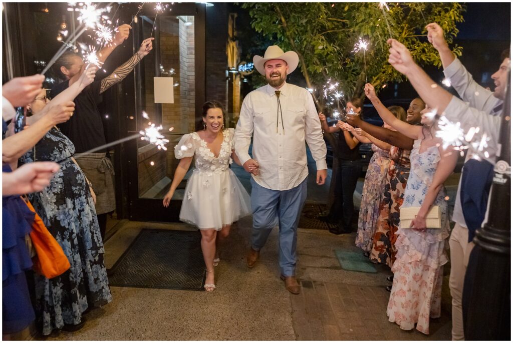 Guests doing a send off of bride and groom with sparklers
