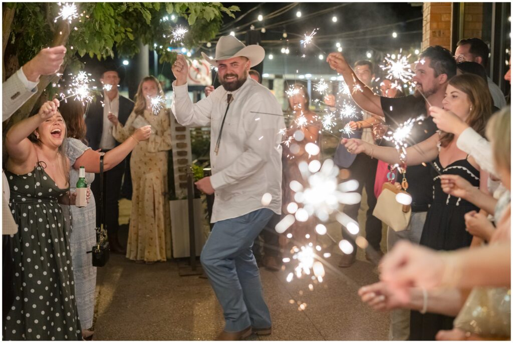 Groom dancing down line with guests holding sparklers