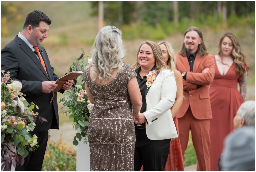 Bride smiling while holding hands during wedding ceremony