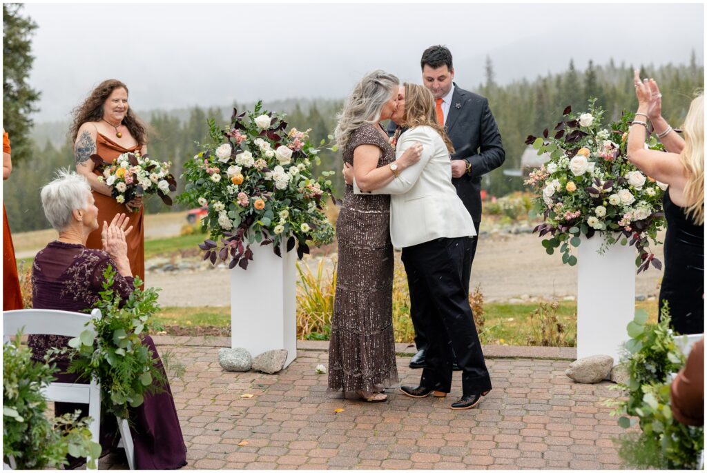 Brides kissing at end of wedding ceremony